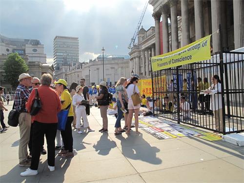 '图3:二零一八年六月三日下午,英国法轮功学员在伦敦特拉法加广场北台阶广传播真相,法轮大法的纯正能量吸引广大民众踊跃了解真相'