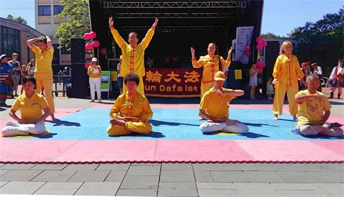 '图1:法轮功学员在舞台上展示五套功法'