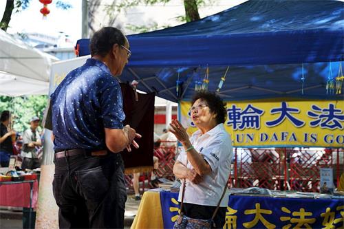 '图1~3:法轮功学员在波士顿中国城主街联欢会上向游客讲真相'