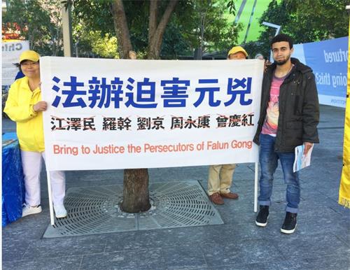 '图14:来自中东国家的年轻人与横幅留影,支持法轮功反迫害'