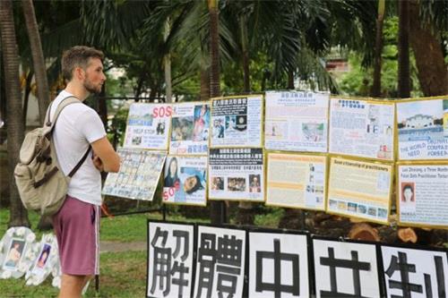 '图2~3:过往游客驻足了解法轮功真相'