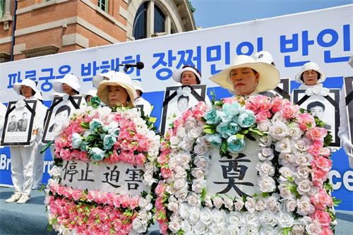 '图3:集会上学员们默哀悼念那些在迫害中失去生命的法轮功学员。'