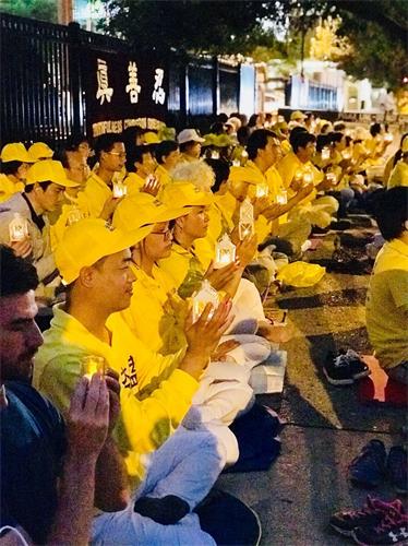 '图1~7:二零一八年七月二十一日,来自美国中部的部份法轮功学员们,静静的坐在芝加哥中领馆对面,手捧点点烛光,悼念那些在中国大陆被中共迫害致死的法轮功学员。'