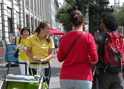'图2~3:柏林街头,法轮功学员向民众讲真相'