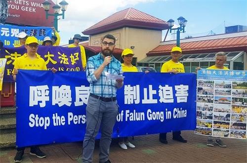 '图2:加拿大国会议员加内特·吉恩内斯委托助理安德鲁·麦迪尔在集会上发言'