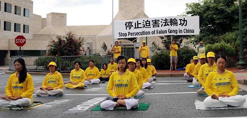 '图2:二零一八年七月二十二日傍晚,美国华府地区部份法轮功学员冒着风雨在中共驻美国大使馆前炼功,呼吁停止迫害法轮功。'