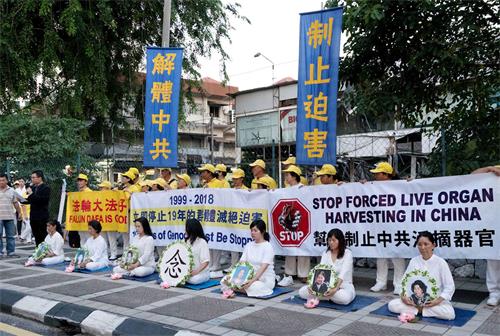 '图1~2:2018年7月20日,马来西亚法轮功学员来到中共使馆,在车水马龙的大路旁举行集会,悼念被中共迫害致死的法轮功学员。'