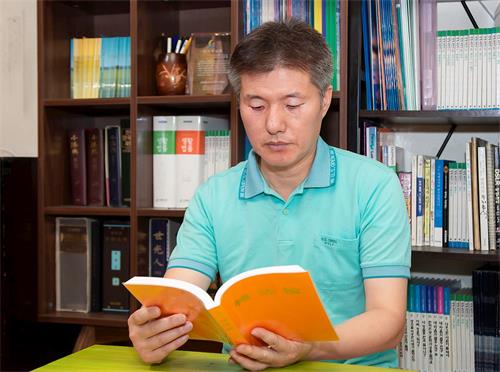 '图1:李惇荣律师在读法轮大法书籍。'