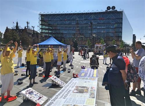 '图3~6:下午,法轮功学员来到哥本哈根政治和商业中心的市政厅广场集会,继续传播法轮功的真相,许多民众驻足观看、了解真相。'