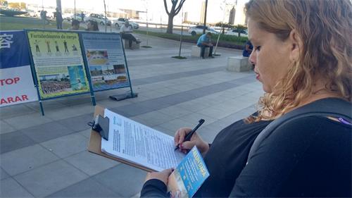 '图7:卢西亚娜(Luciana)眼含泪水签名谴责中共迫害'