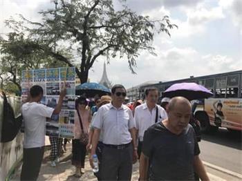 '图:魏敏(打真相展板者)在泰国景点讲真相'