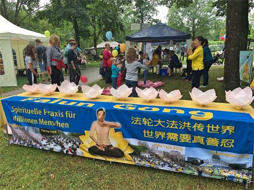 '图1:二零一八年七月二十二日,德国巴特克茨廷法轮功学员应邀参加巴伐利亚中部报社(Mittelbayerische?Zeitung)?该市疗养公园(Kurpark)举办的儿童节,为孩子和家长提供免费教功。'