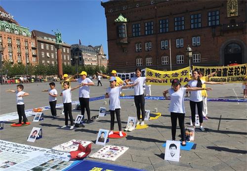 '图2:夏令营的孩子们周六下午参加哥本哈根市政厅广场的七·二零反迫害活动,展示法轮功五套功法'