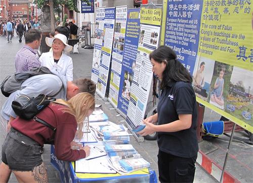 '图3~4:民众驻足认真了解真相后签名支持法轮功反迫害'