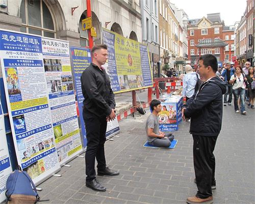'图6:二零一八年八月十一日,在伦敦法轮功学员杰克帮助下,一位来自立陶宛的年轻商界人士(左)第一次尝试法轮功功法,惊呼神奇'