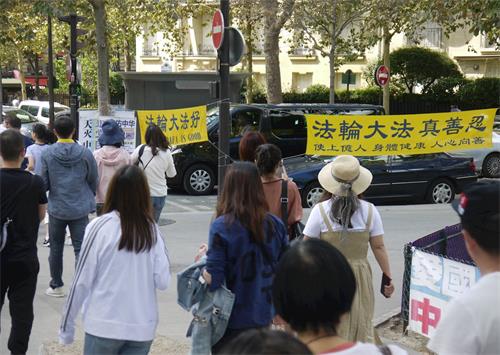 '图1~2:艾菲尔铁塔下,每天都有很多大陆游客经过法轮功真相点。'