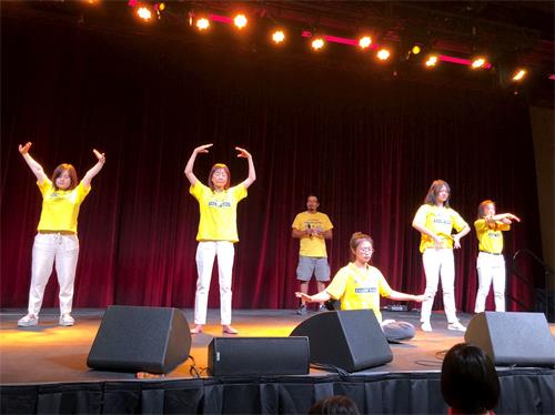 '图6:学员们在舞台上表演五套功法,一名西人学员在讲解;'