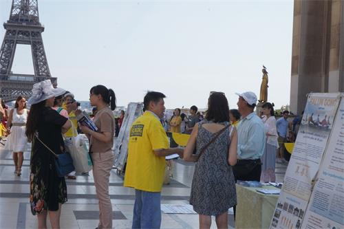 '图7:8月19日,来自大陆的生物老师(左一),观看了功法演示后还和法轮功学员交谈,最终退出了中共党团组织。'