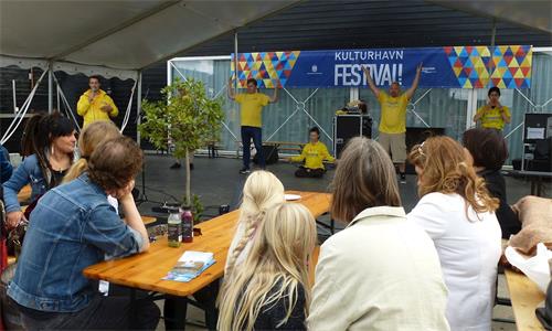 '图2:法轮功功法演示吸引人们的关注'