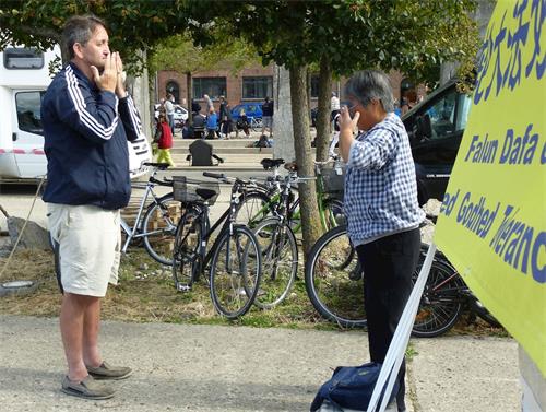 '图3:胡安女士(右)现场学炼法轮功'