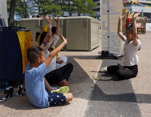 '图4:彻可·德玛(Chirky Delmar,左二)女士带着儿子一起学炼法轮功'