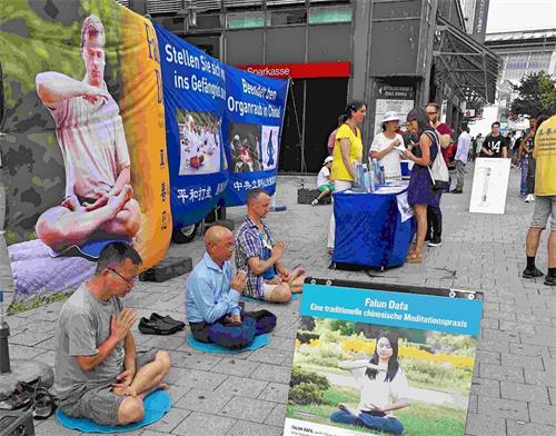 '图1:二零一八年八月四日,汉堡法轮功学员在位于市中心的火车站前设立信息点,传播法轮功的真相,揭露中共的迫害。'