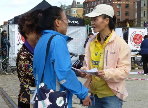 图5:华裔母女认真听法轮功学员讲真相