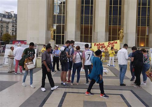 '图1~2:二零一八年九月九日,?巴黎人权广场上,游人观看展板,了解法轮功真相'