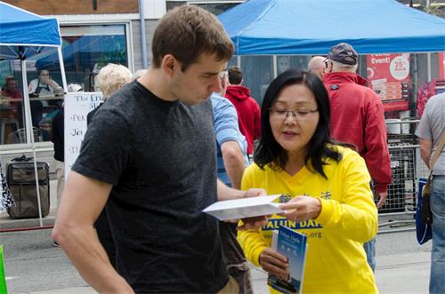 '图4:艾伦先生在听学员给他介绍法轮功。'