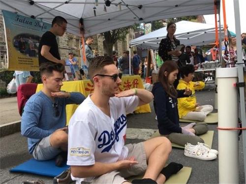 '图4:纽约州府奥伯尼云雀节上,人们现场学炼法轮功。'