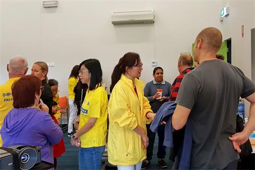 '图3:参加集体炼功的社区民众与法轮功学员交谈'
