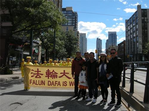 '图5:来自于越南的Scuong先生和朋友一行大小六人与法轮功学员游行队伍合影'
