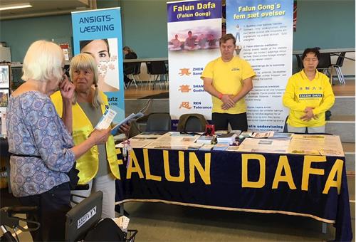 '图2~3:博览会上来往的民众了解法轮功真相'