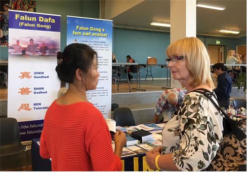 '图6:伊莎贝尔(Issebell)女士(右)脊柱疼痛,当她得知炼法轮功能够祛病健身,非常高兴,表示要学。'