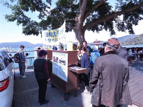 '图2:日月潭伊达邵景点大陆民众观看真相展板'