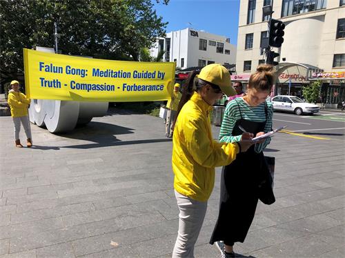 '图3:听闻真相的人们签名支持法轮功。'