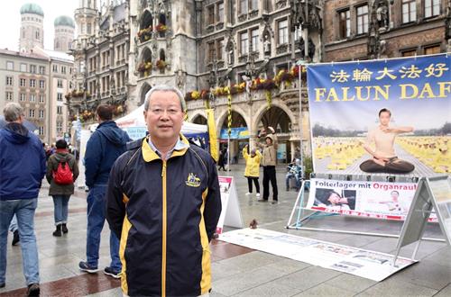 '图7:前北大经济学教授夏业良在慕尼黑玛琳广场两次遇到法轮功学员举办活动。图为十月七日夏教授在慕尼黑玛琳广场。'