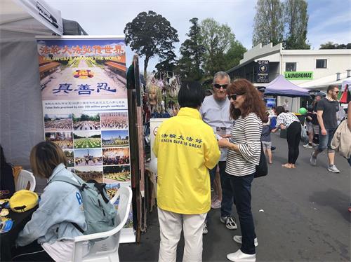 '图3~4:不少民众来到法轮大法展位学习和了解法轮功。'