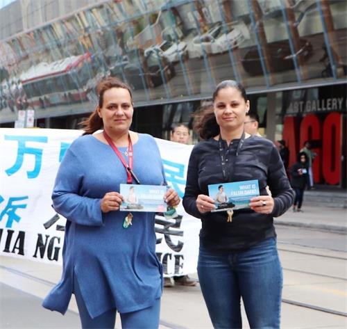 '图22:在市中心上班的塔雅(Taya 左)和她的同事拉塔莎(Latasha 右)一起观看了游行'