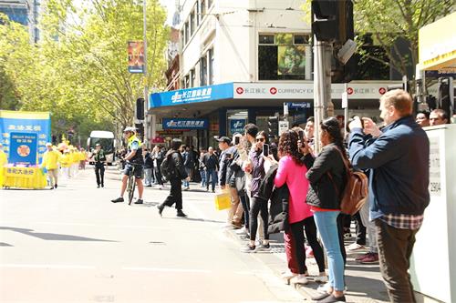 '图16~17:二零一九年十月十一日星期五,游客和当地民众被法轮功学员游行队伍吸引,纷纷拍照、驻足了解真相。'
