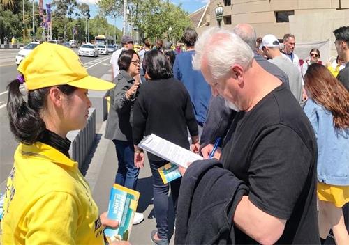 '图5:明真相的市民和游客在征签表上签名,呼吁立即停止迫害。'