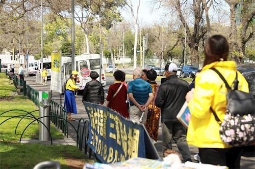 '图9:法轮功学员在著名景点费茨罗伊公园设立法轮大法信息台。'