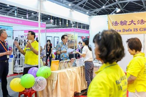 '图1~3:二零一九年十月十一日至十三日,法轮功学员在新加坡博览中心(Singapore Expo)举办的健康保健展上设立展位,向人们介绍法轮功,并免费教功。'