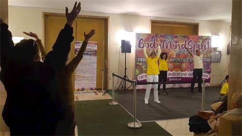 '图:法轮功学员还在展示舞台那里每天定时为过往民众介绍和演示法轮功修炼方法,很多民众开始学炼'