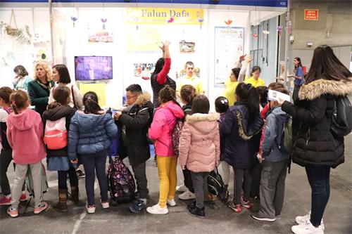 '图5:学生驻足观看法轮功学员的功法展示'