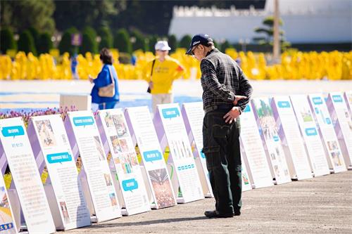 '图7~10:自由广场上,法轮功真相展板吸引游客关注。'