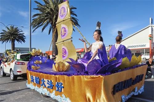 '图3:仙女打扮的学员在花车上展示法轮功功法'