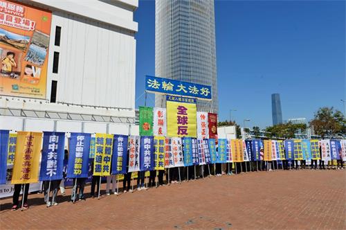 '图2:法轮功学员在集会上展示各式幡旗,呼吁三退保平安,以及法办元凶、解体中共。'