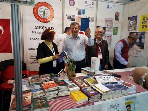 '图11:著名记者穆斯塔法·巴尔贝(Mustafa Balbay)高兴地举着《转法轮》'