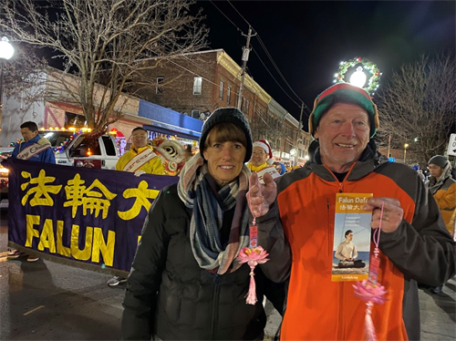 '图6:参加游行的Ed夫妇表示他们家人都喜欢印有中英文“法轮大法好”的莲花吊坠。'